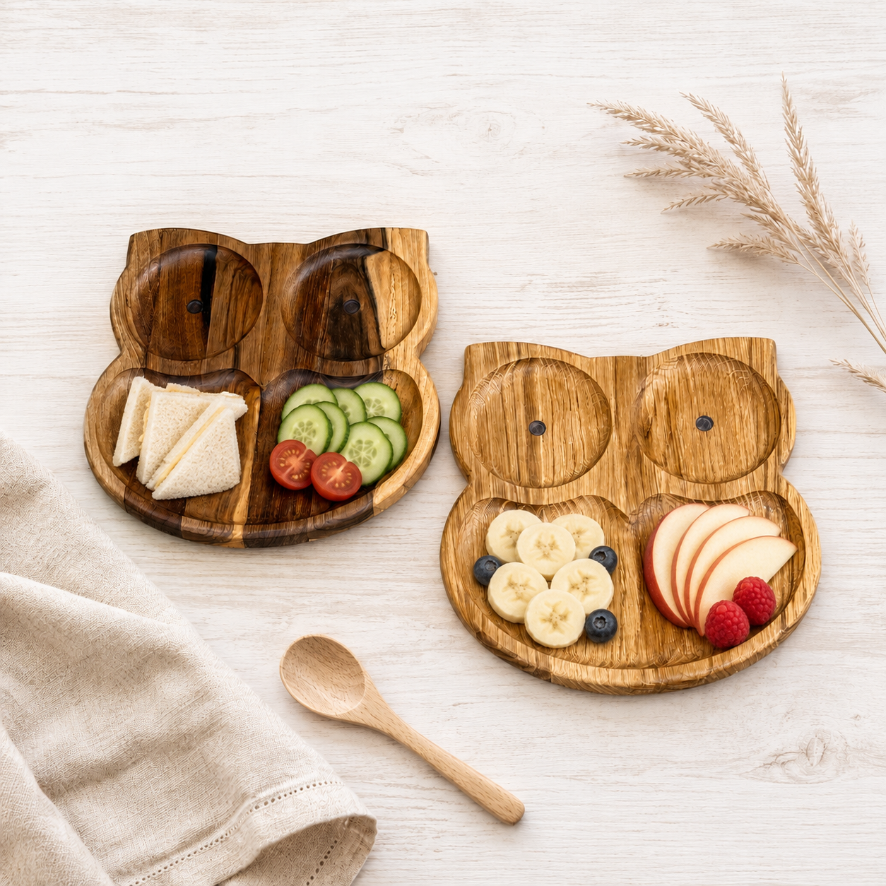 Eulen-Kinderteller aus Eiche und Walnuss, angerichtet mit Sandwich, Gemüse, Banane, Beeren und Apfel.
