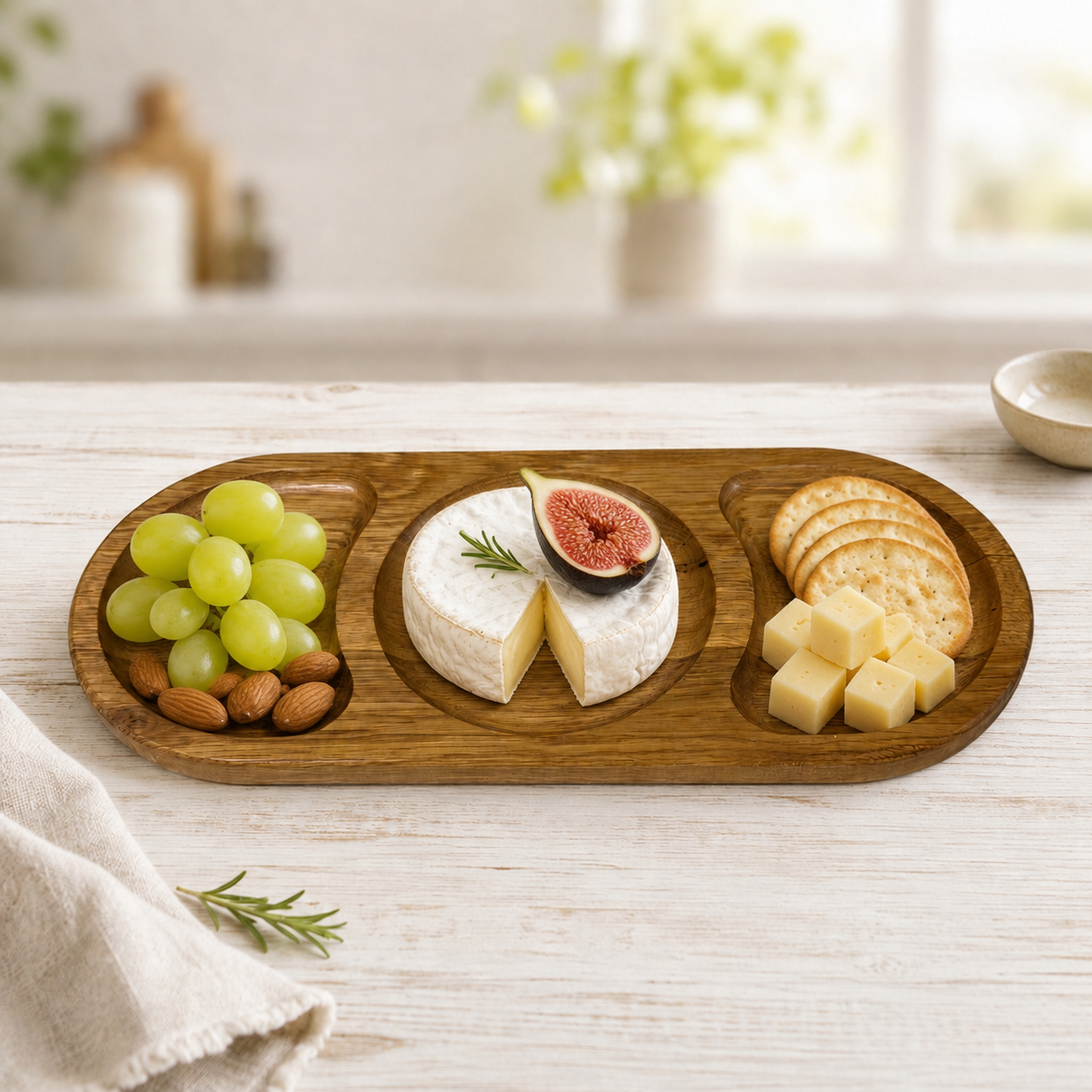 Snackteller aus Eichenholz mit drei Fächern, angerichtet mit Käse, Trauben und Crackern
